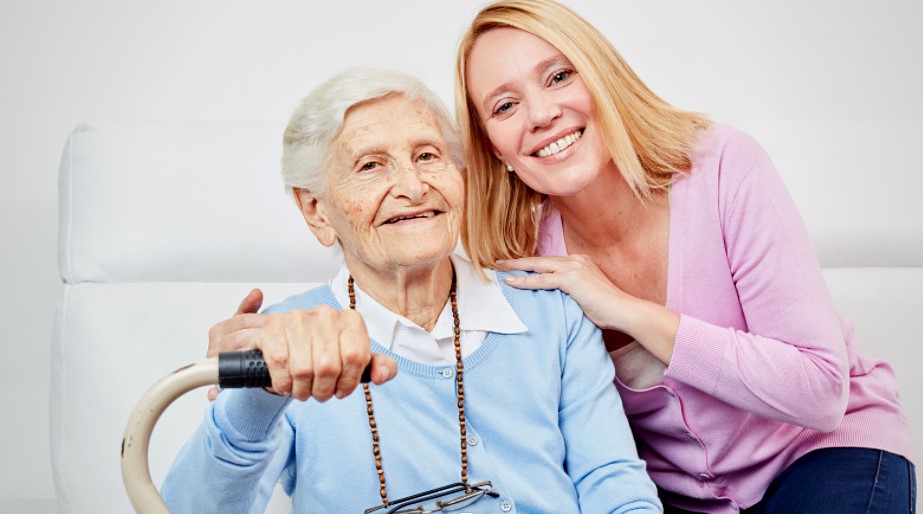 Senior woman and adult woman seated smiling at camera